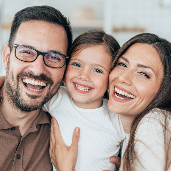 young adult couple with daughter smiling