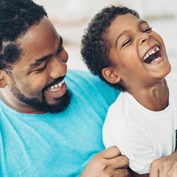 adult male and young son laughing