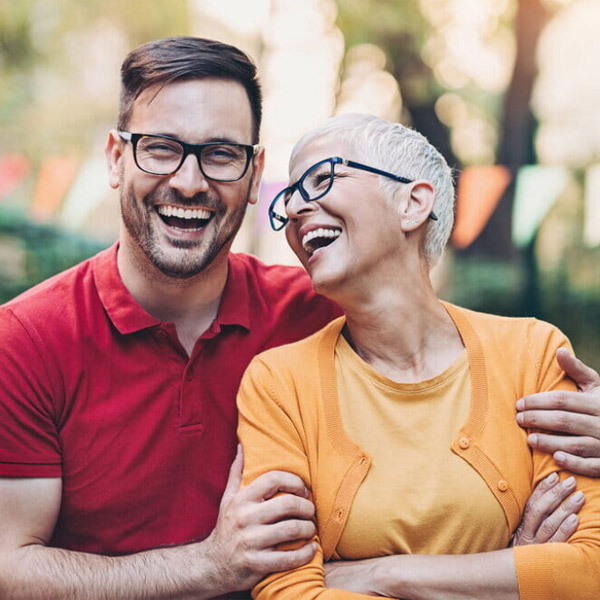 Adult man laughing with older woman